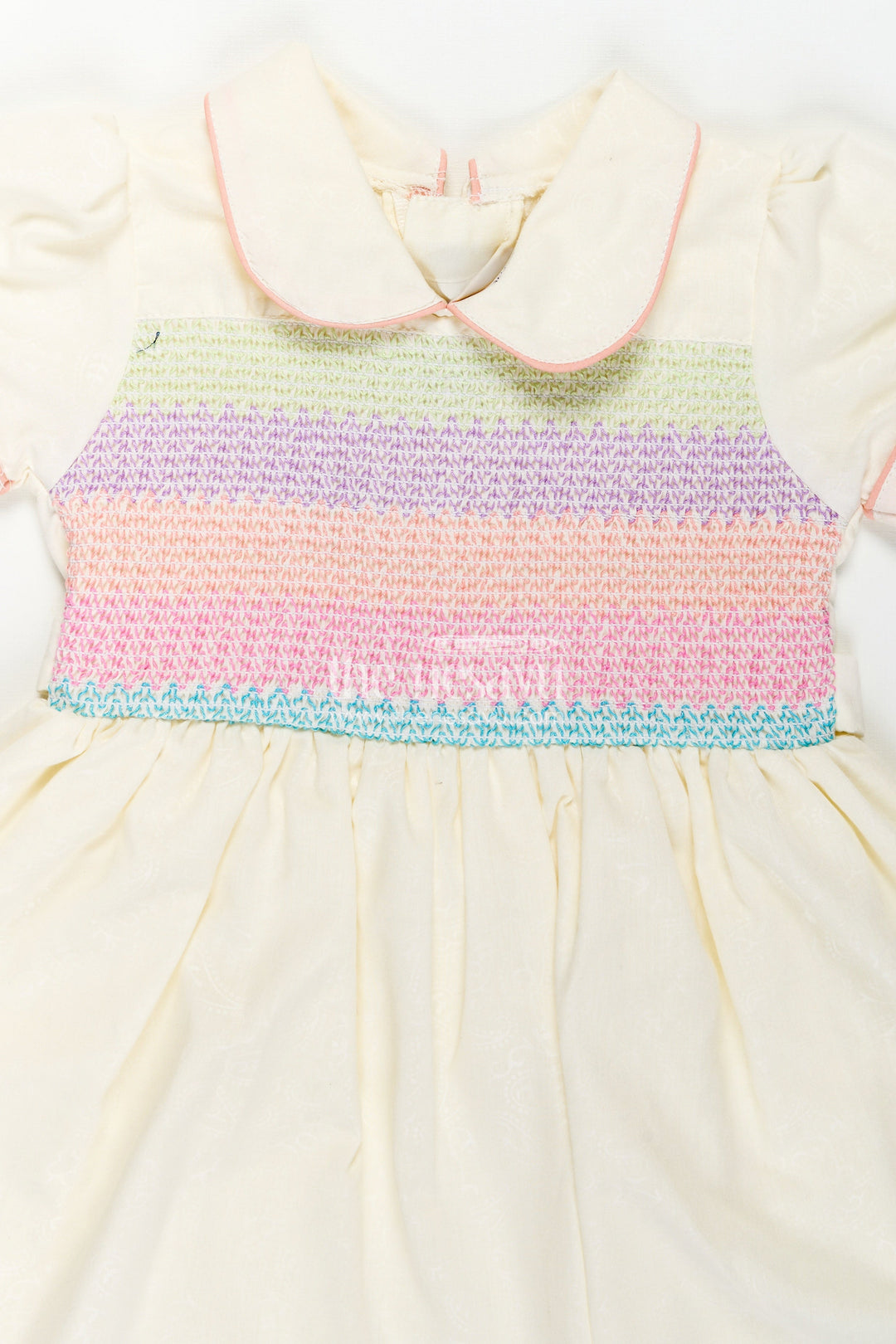 The Nesavu Girls Cotton Frock Archive -Girls Short Frock White Colour with Smocked Rainbow Yoke and Peter Pan Collar in Soft Cotton Blend Nesavu Nesavu Girls Short Frock White Colour Rainbow Smocked Yoke Peter Pan Collar