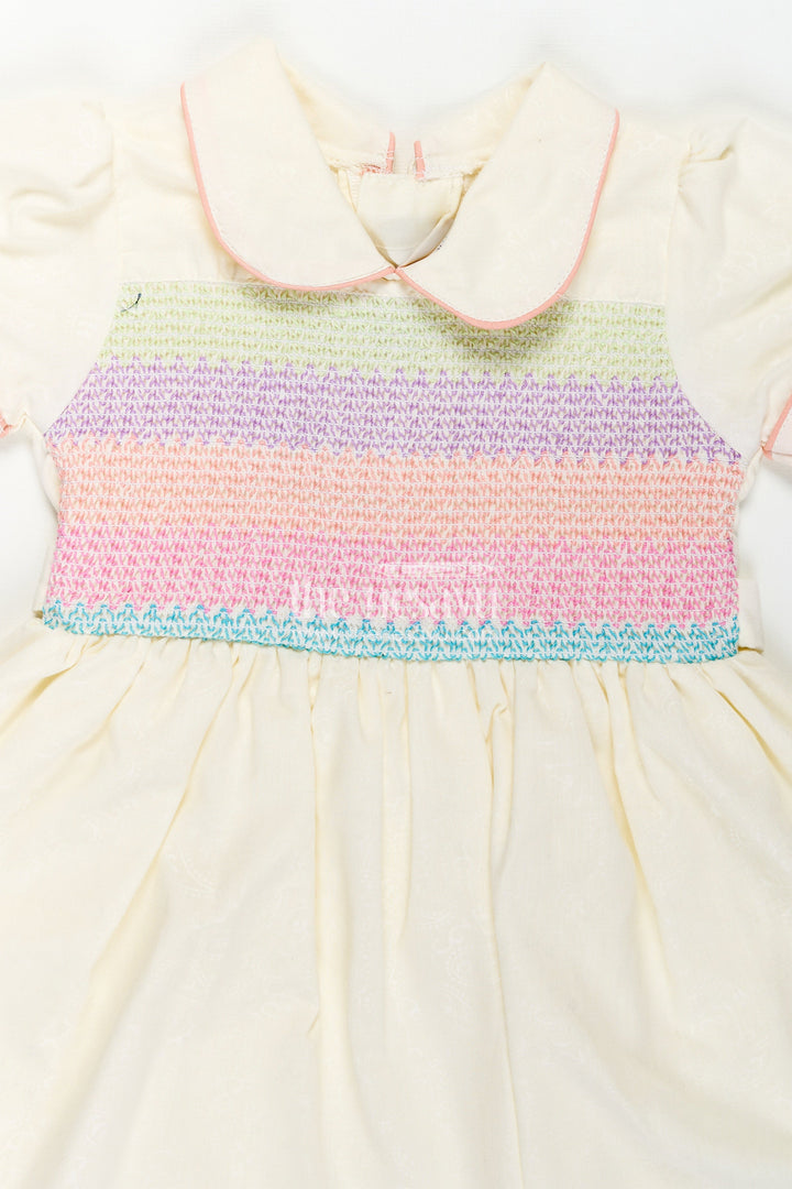 The Nesavu Girls Cotton Frock Archive -Girls Short Frock White Colour with Smocked Rainbow Yoke and Peter Pan Collar in Soft Cotton Blend Nesavu Nesavu Girls Short Frock White Colour Rainbow Smocked Yoke Peter Pan Collar