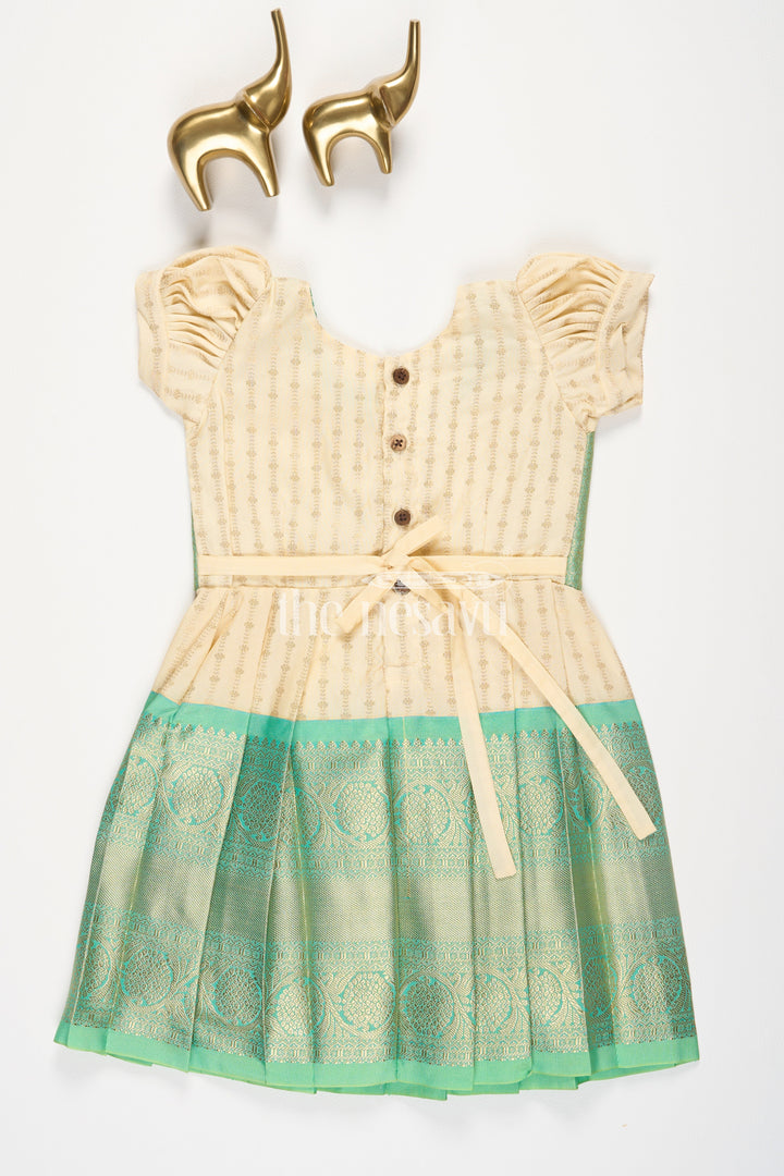 The Nesavu Girls Kanchi Silk Frock Cream and Green Semi Kanchivaram Silk Frock with Golden Stripes and Brocade Border for Girls Nesavu Nesavu Cream Green Semi Kanchivaram Silk Frock Brocade Border Puff Sleeves Girls