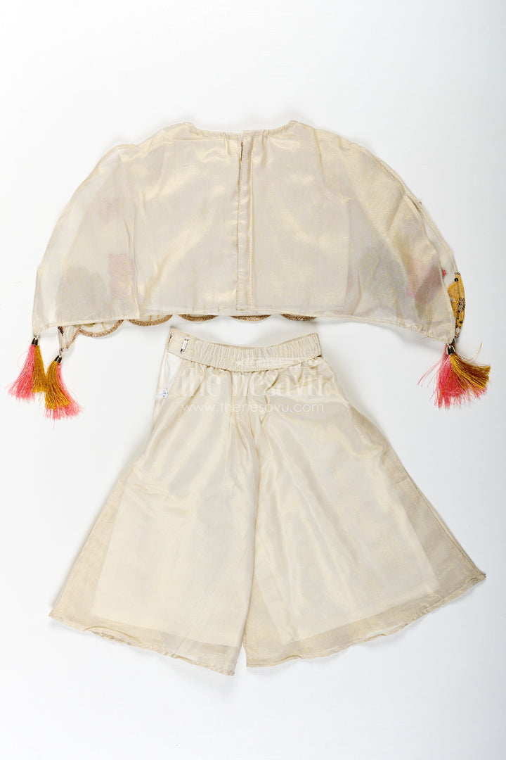 The Nesavu Girls Sharara / Plazo Set Cream Color Sharara Set for Girls in Shimmer Viscose Silk with Designer Embroidered Cape and Tassels Nesavu Girls Cream Color Sharara Set Embroidered Shimmer Cape Top Flared Silk Pants | The Nesavu