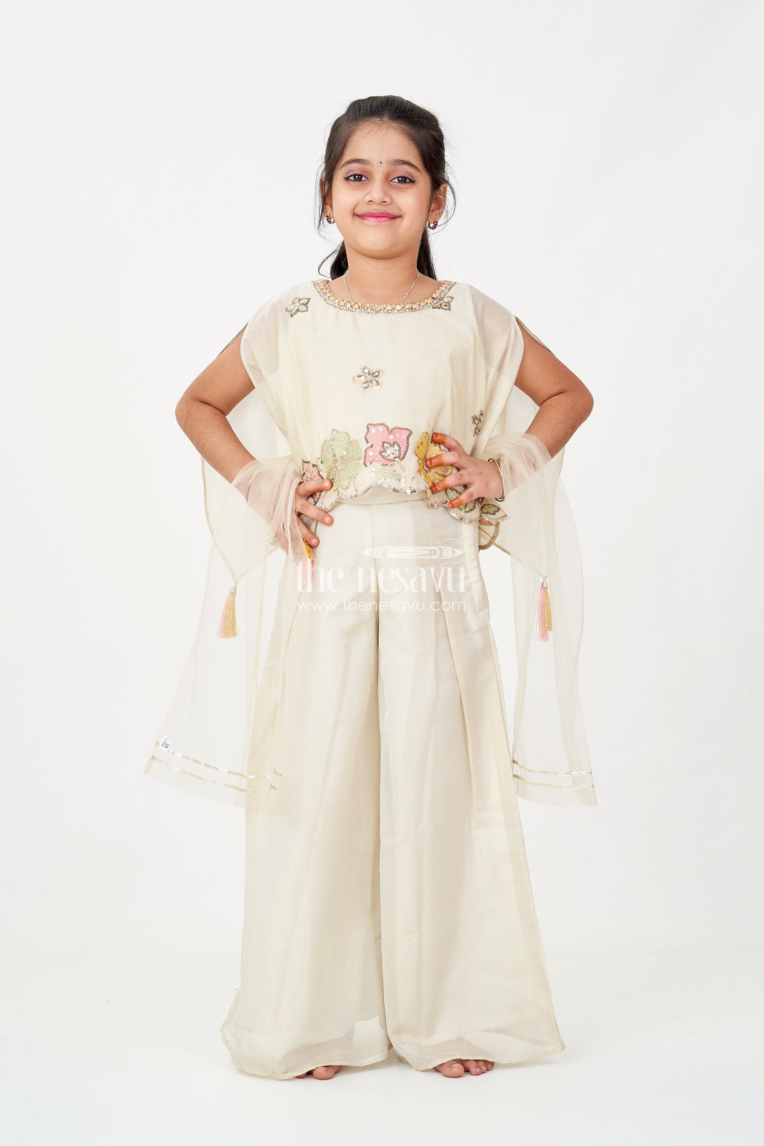 The Nesavu Girls Sharara / Plazo Set Cream Color Sharara Set for Girls in Shimmer Viscose Silk with Designer Embroidered Cape and Tassels Nesavu Girls Cream Color Sharara Set Embroidered Shimmer Cape Top Flared Silk Pants | The Nesavu