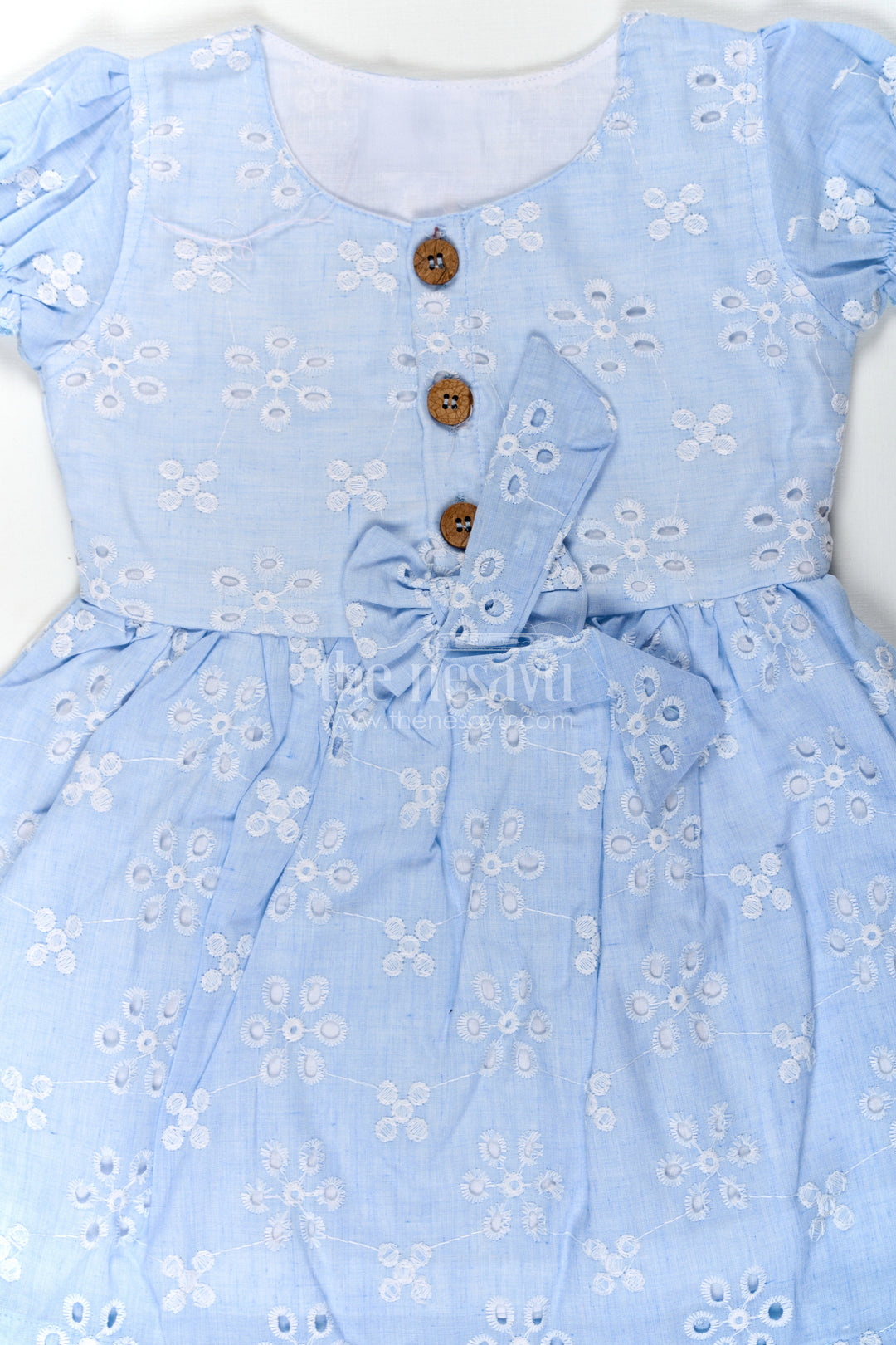 The Nesavu Girls Cotton Frock Girls Casual Wear Party Dress in Sky Blue Hakoba with Bow Belt and Wooden Button Detail Nesavu Casual Wear Party Dress for Girls in Sky Blue Hakoba with Embroidery and Waist Bow | The Nesavu