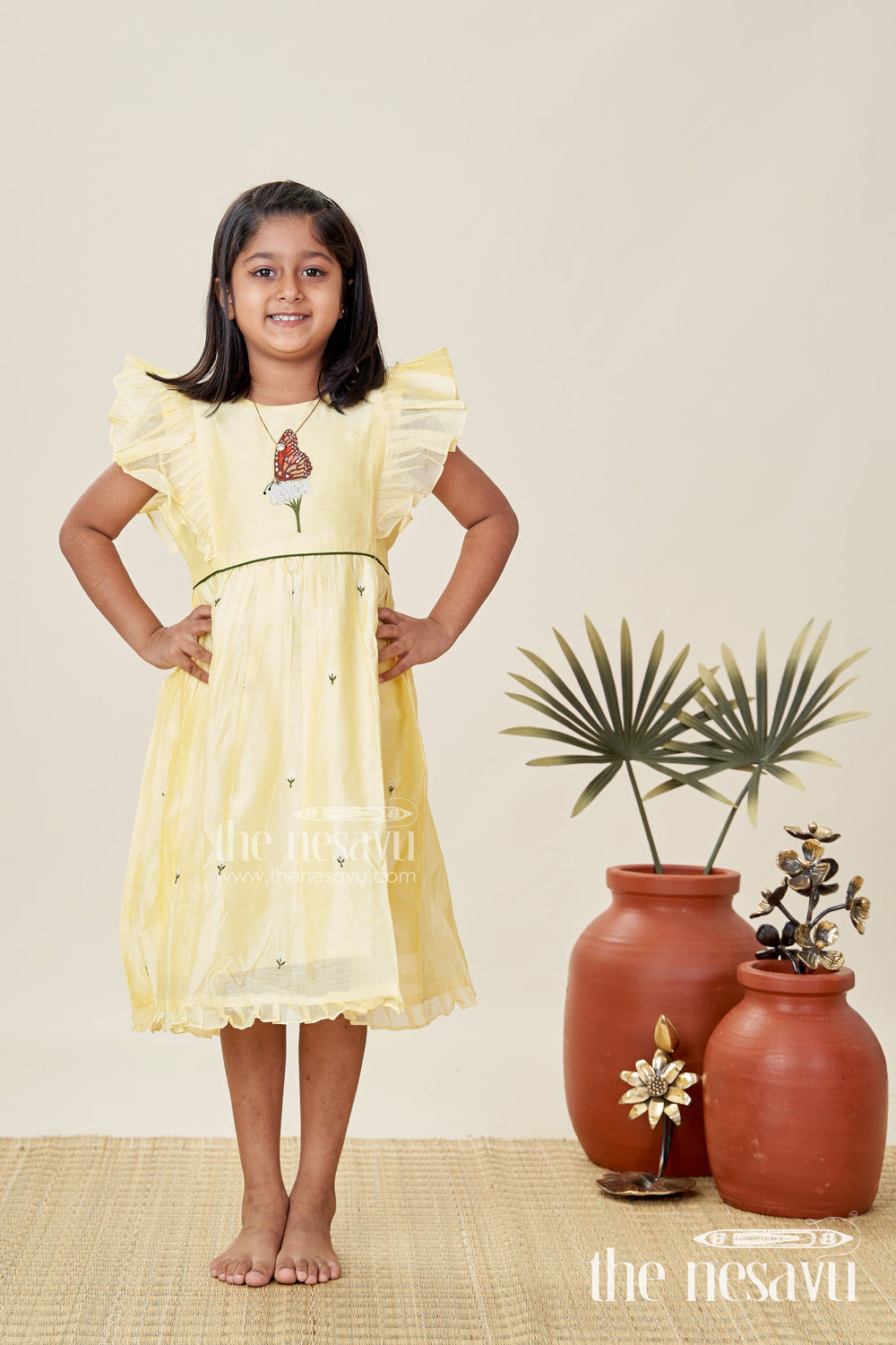 The Nesavu Girls Chanderi Frock Girls Chanderi Cotton Beautiful Frock Design with Butterfly Embroidery and Ruffle Sleeves in Soft Yellow Nesavu Nesavu Girls Chanderi Cotton Yellow Frock Butterfly Embroidery Beautiful Ruffle Design