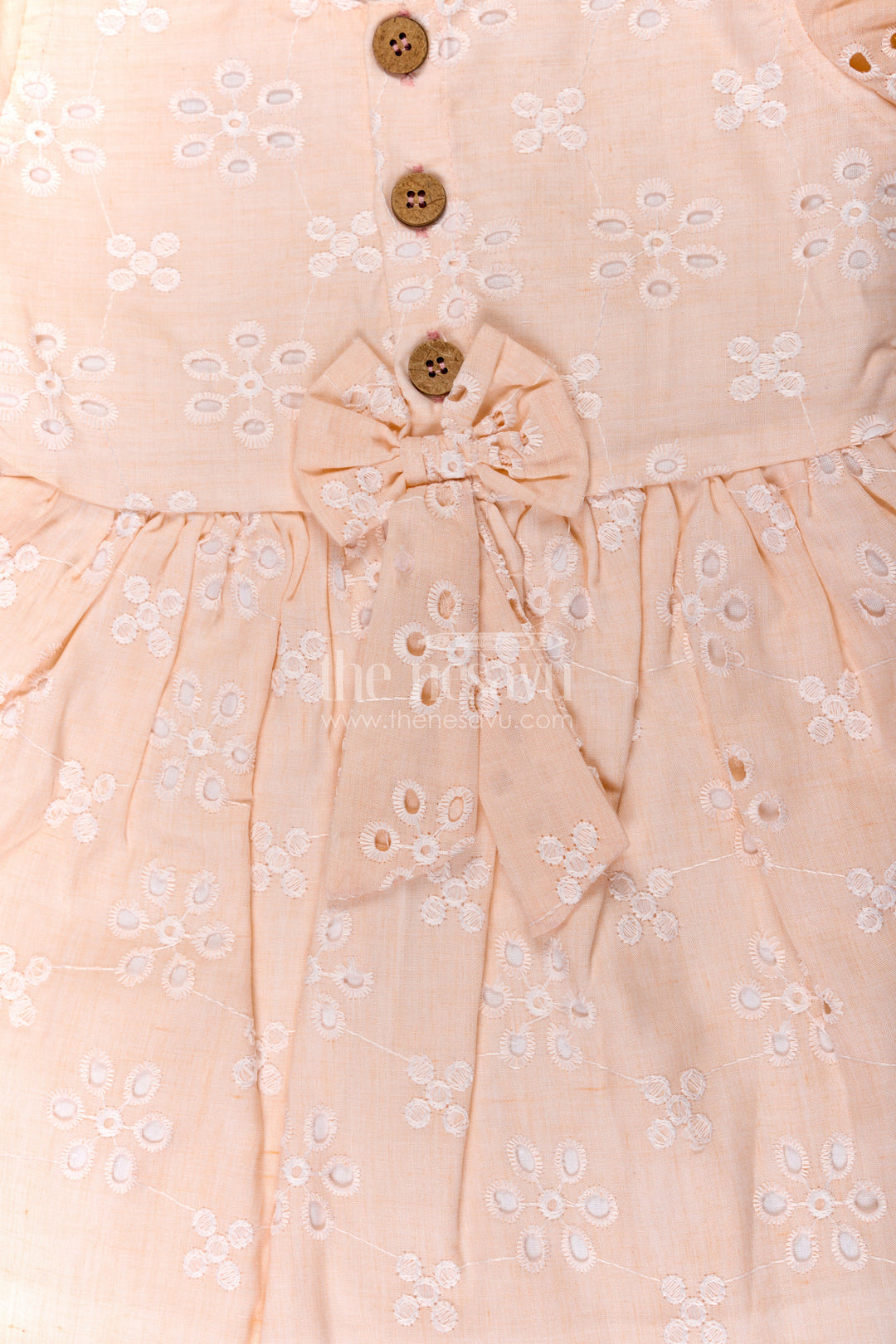The Nesavu Girls Cotton Frock Girls Cotton Sleeveless Dress in Pastel Peach with All-Over Hakoba Floral Embroidery Nesavu Cotton Sleeveless Dress for Girls in Peach Hakoba Fabric with Embroidery and Button Detail | The Nesavu