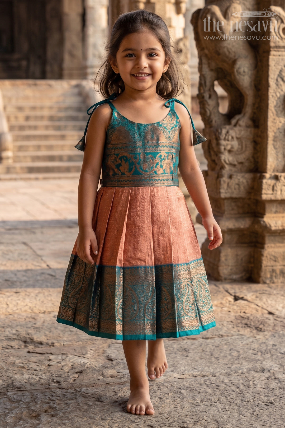 The Nesavu Tie-up Frock Girls Ethnic Silk Dresses in Semi Kanchivaram with Tie Up Sleeves and Zari Woven Orange Green Pleated Skirt Nesavu Ethnic Silk Dresses for Girls in Semi Kanchivaram with Orange Green Zari Pleated Tie Up Frock | The Nesavu