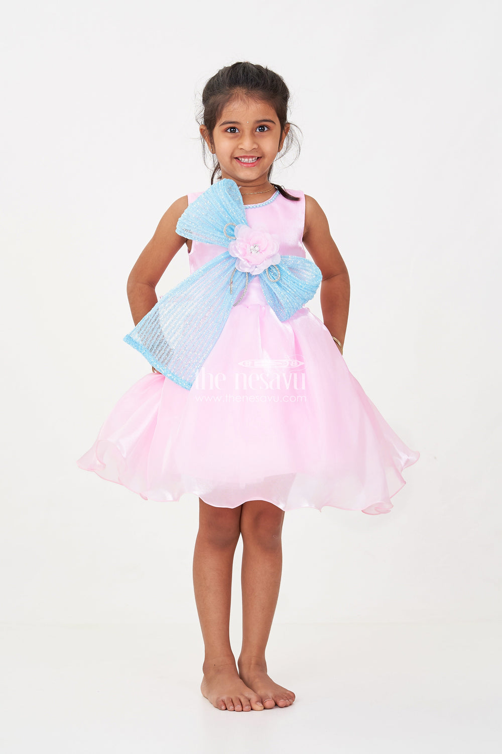 The Nesavu Girls Fancy Party Frock Girls Pink Net Frock with Blue Glitter Bow and Floral Accent in Glazed Organza Fabric Nesavu Nesavu Girls Pink Net Frock Blue Glitter Bow Glazed Organza Party Wear