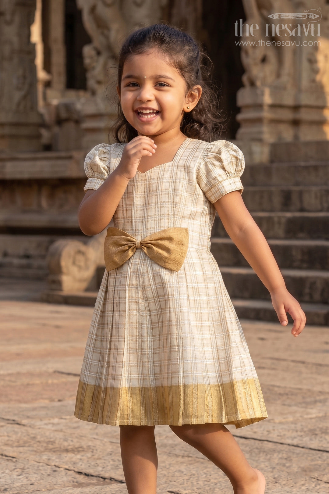 The Nesavu Silk Frock Girls Short Frocks for Party in Beige Silk with Gold Bow Embellishment and Checked Pleated Design Nesavu 16 (1Y) / Cream SF1010B-16 Nesavu Girls Short Frocks Party Beige Silk Gold Checked Pleats Bow Embellishment