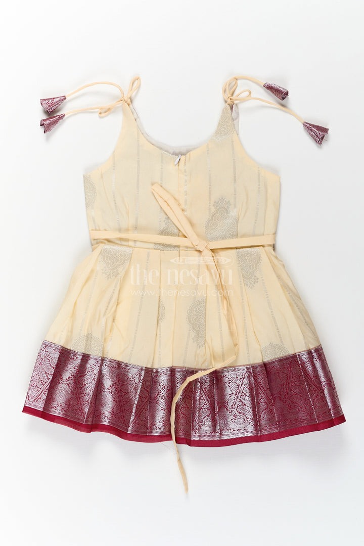 The Nesavu Tie-up Frock Girls Silk Dress Maroon in Semi Kanchivaram with Tie-Up Sleeves and Elegant Golden Pleated Zari Border Skirt Nesavu Girls Silk Dress Maroon Tie-Up Frock in Semi Kanchivaram with Golden Mid Panel and Zari Pleats | The Nesavu