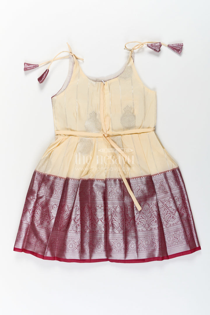 The Nesavu Tie-up Frock Girls Silk Dress Maroon in Semi Kanchivaram with Tie-Up Sleeves and Elegant Golden Pleated Zari Border Skirt Nesavu Girls Silk Dress Maroon Tie-Up Frock in Semi Kanchivaram with Golden Mid Panel and Zari Pleats | The Nesavu