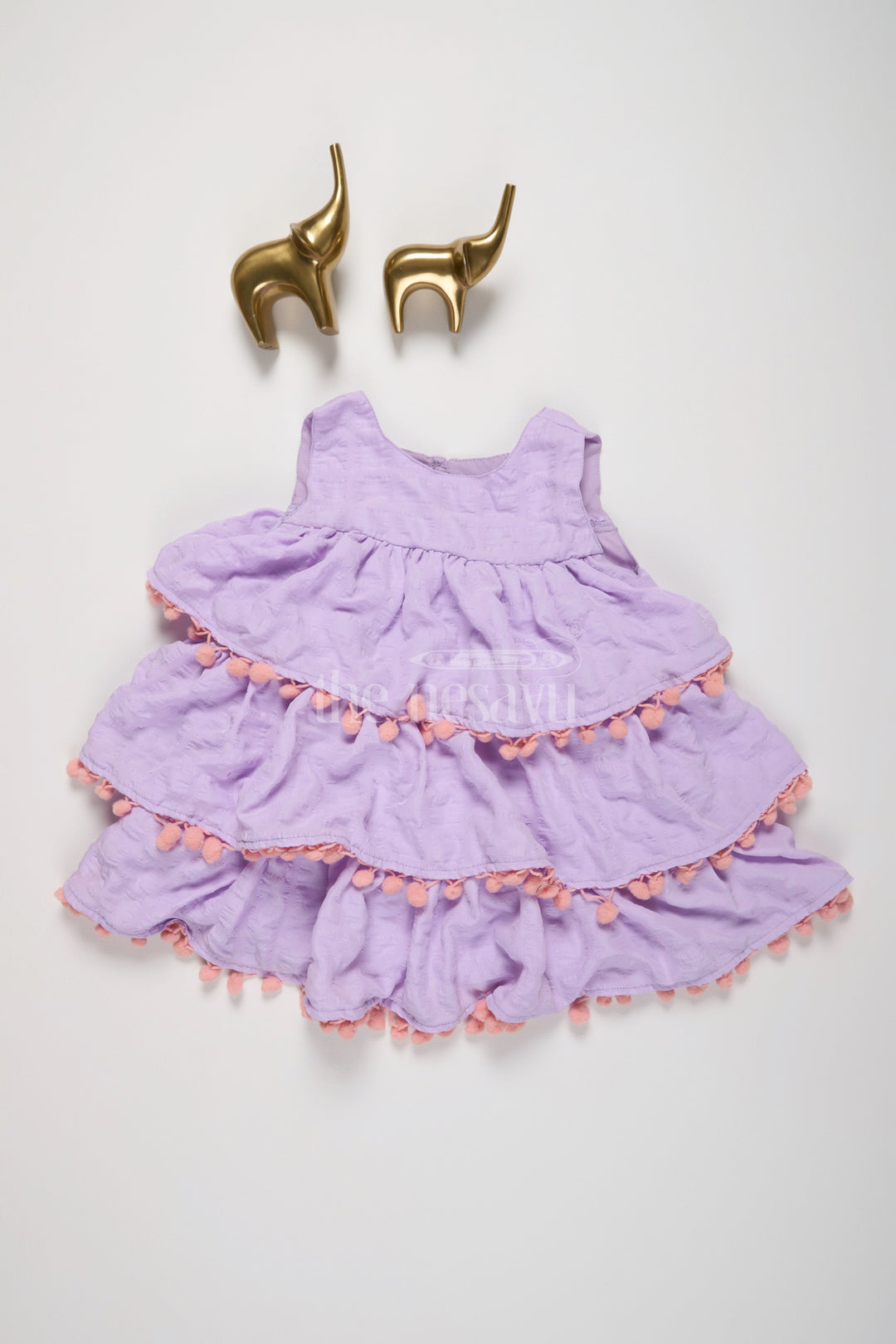 The Nesavu Girls Fancy Frock Lilac-Tiered Girls Fancy Frock with Pom-Pom Trim and Sleeveless Design for Parties Nesavu Nesavu Lilac-Tiered Girls Fancy Frock Pom-Pom Trim Textured Fabric Birthday Parties