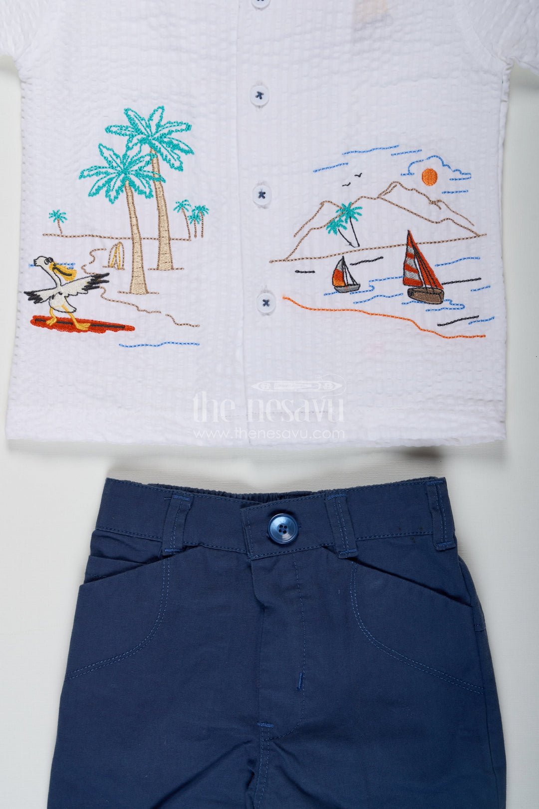 The Nesavu Boys Casual Set Thread Embroidery Boys Casual Shirt Set with Beach Scene Motif and Navy Blue Shorts in Crush Cotton Blend Nesavu Thread Embroidery Boys Shirt Set with Beach Motif in Crush Cotton and Navy Blue Shorts | The Nesavu