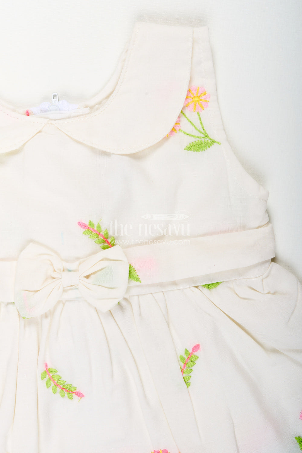 The Nesavu Baby Cotton Frocks White frock for baby girls with floral embroidery and waist bow Nesavu Nesavu white cotton frock for baby girls with bow and floral embroidery for casual dressing