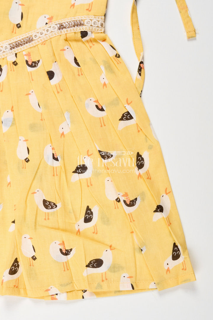 The Nesavu Tie-up Frock Yellow Tie-Up Cotton Frock for Toddler Girls with Playful Bird Print Nesavu Nesavu yellow cotton tie-up frock for toddler girls with playful bird print and pleated flare